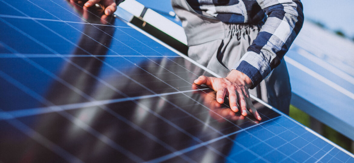 Man worker in the firld by the solar panels